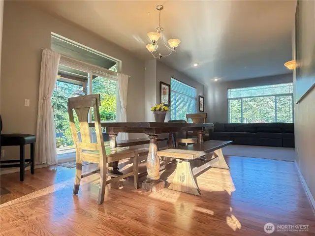 Sunlight streaming in through the kitchen windows illuminating the dining room.