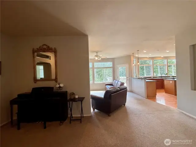 Looking from the entry towards the family room and kitchen with music and bonus gathering space to the left.