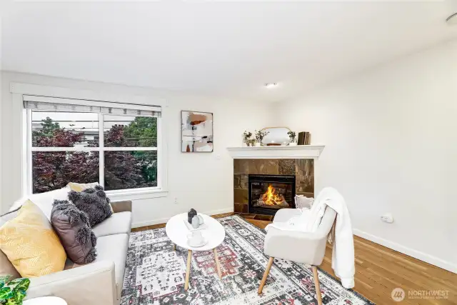 Living room with wood floors, corner fireplace, and great natural light