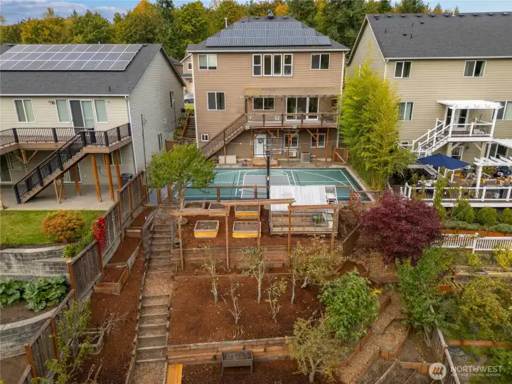 Terraced garden beds, added sports court, solar panels, extended back balcony! Outdoor oasis ready for you.