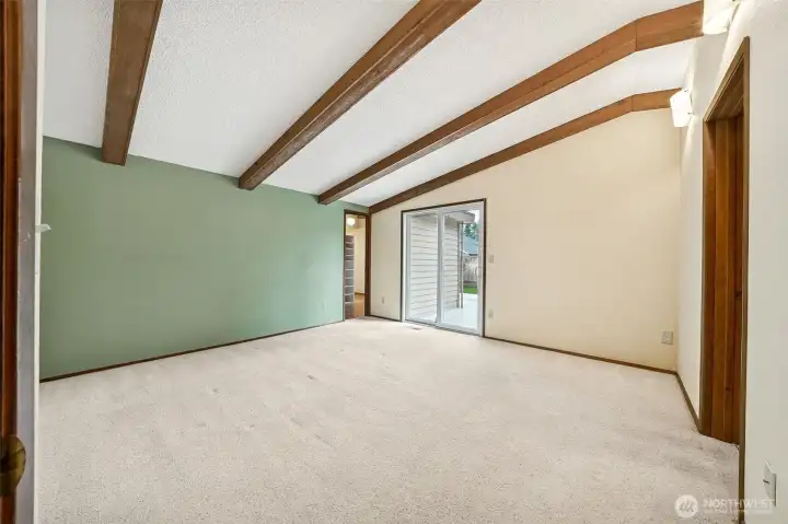 Primary bedroom continues the beautiful exposed beams and vaulted ceilings.