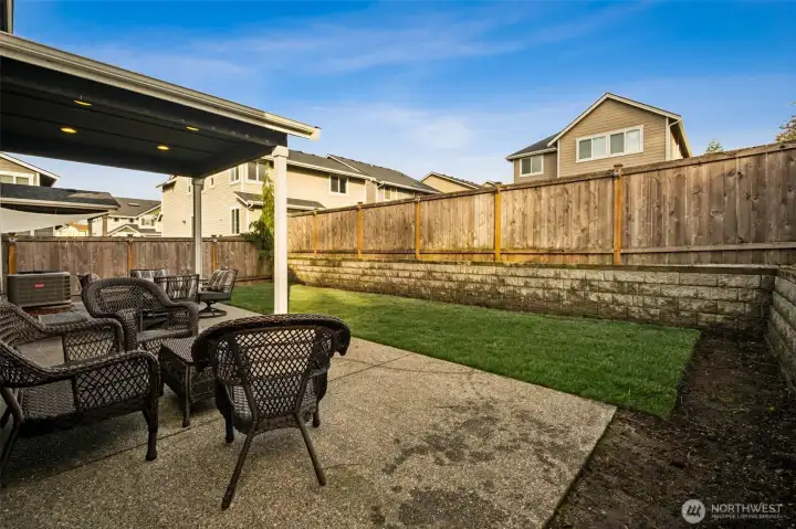 Extended patio space overlooking a generous lawn — ideal for gatherings and BBQs.