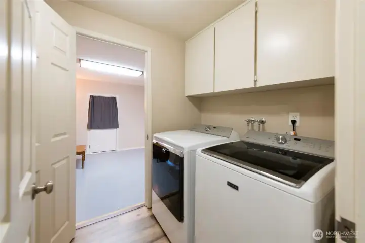 Laundry room with sink and built-in cabinetry for extra storage space.