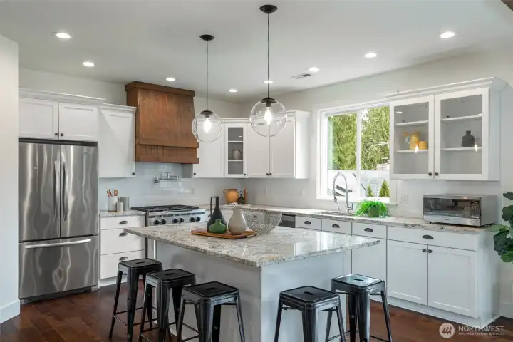 The inviting great room showcases a two-chef granite kitchen, cozy gas fireplace
