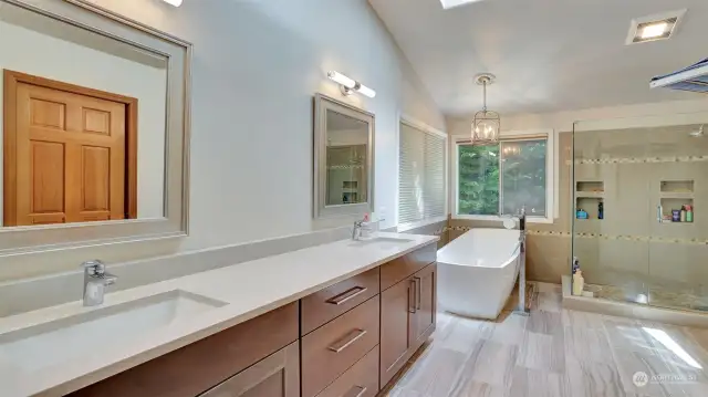 Spa-like bath with double sinks, a soaking tub, heated floors, and a walk-in closet.