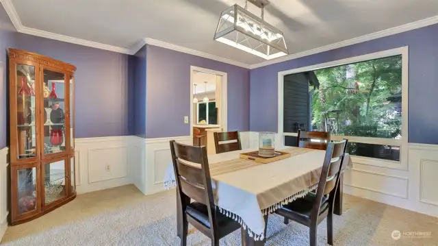 Spacious formal dining room off the kitchen with beautiful wainscotting and picture window.