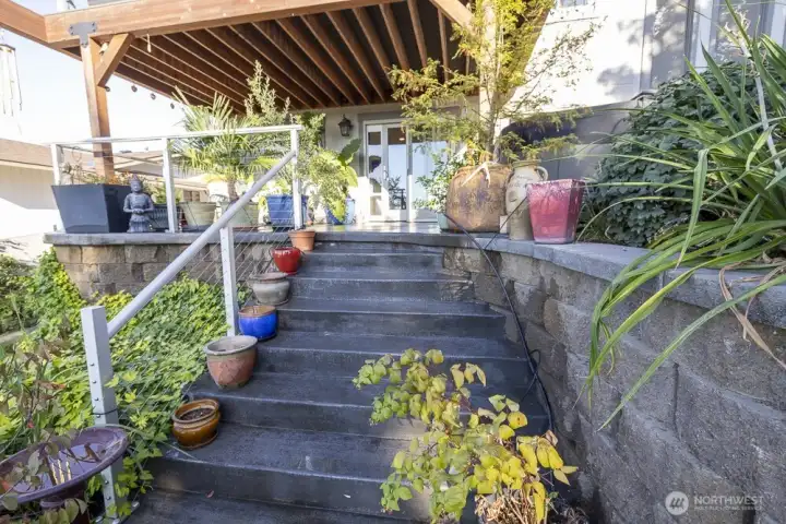 Backyard entrance with terraced steps leading to the lower patio.