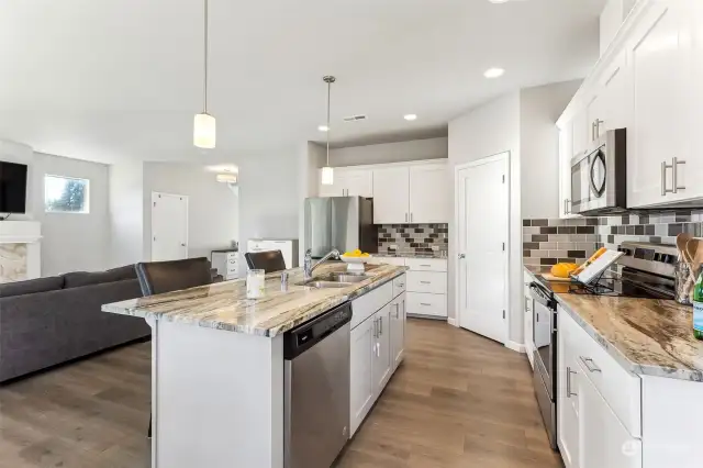 Open kitchen with beautiful countertops and SS appliances