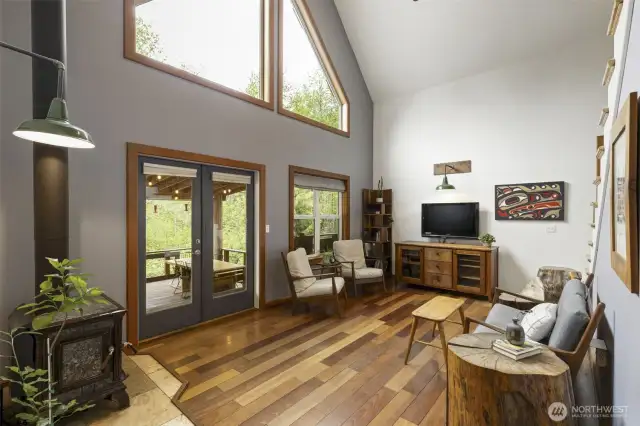 Main living room with wall of windows and access to the incredible, covered back porch. Gleaming hardwoods.