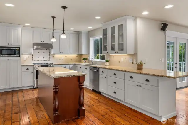 Large kitchen, complete with island, breakfast bar space, and all custom cabinetry!