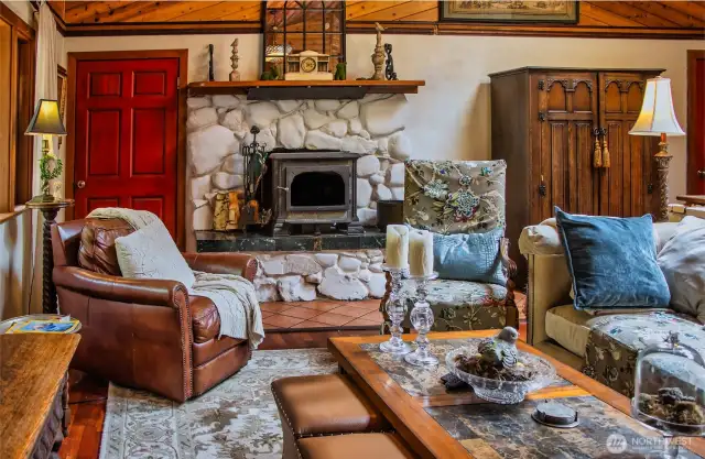 Enter to left is LR with vaulted wood ceilings, skylights and circular fan.  Warm cherry floors with radiant heat. Fireplace insert and rockery wall only occasionally used by owner. Door on left goes to garage.