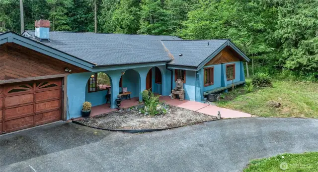 Wood clad windows with lever side opening (screens in garage!)  Front mossy bench is beckoning.