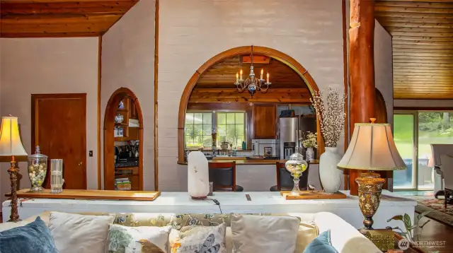 Triple arches embracing the kitchen, located in the heart of the home facing south. Chandelier in center archway does not convey. Left door to utility. Right sliders to outside patio through DR.