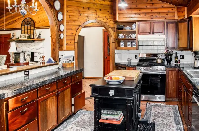 Kitchen centered by archways - New appliances in 2023. Granite counter tops. Wood cabinetry and shelving.
