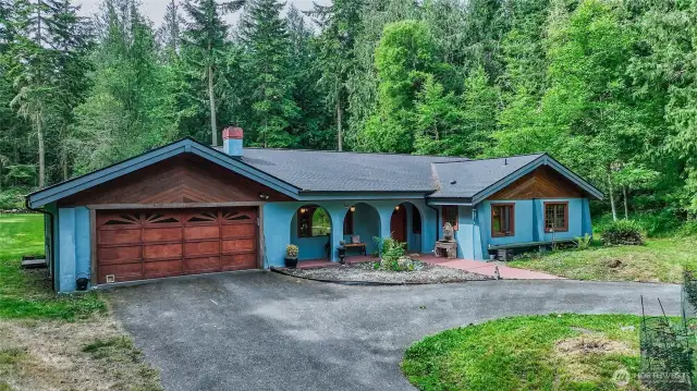 Double car garage with built-ins and insulation, houses propane boiler for radiant floor heat system behind wooden panels. Entry to LR on R as you enter garage, and entry into Studio/Solarium straight ahead through garage.