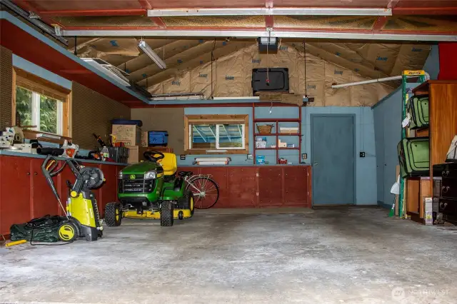 Insulated garage - blue door ahead into studio/solarium - blue sliding panels to right cover propane boiler for radiant floor heat and stove. Built-ins, windows, single garage door. Access to right into LR