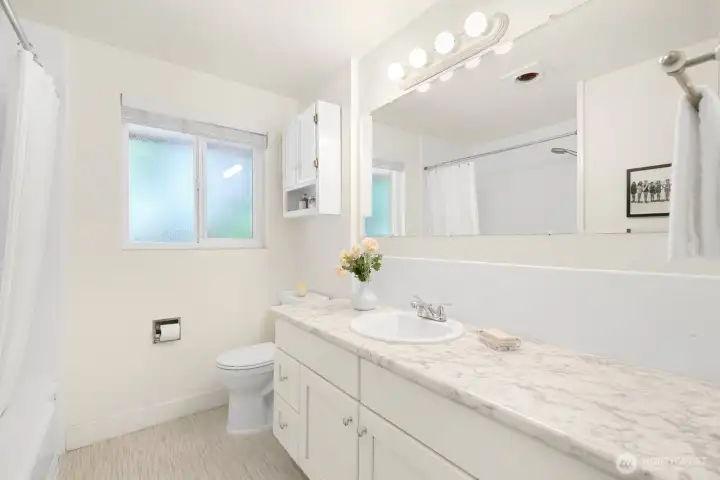 Full bath on the main is cheery and bright too!