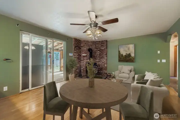 COZY DINING AREA WITH EASY ACCESS TO KITCHEN AND RELAXING WOOD STOVE.