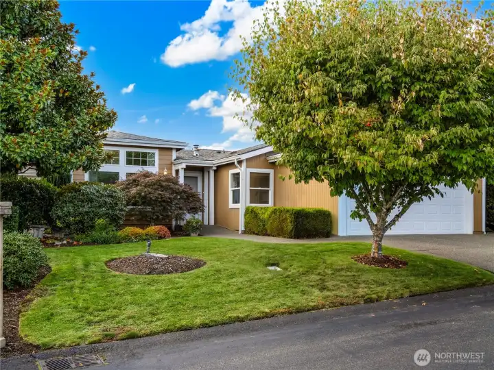 Lush trees and green grass adorns this beautiful home.