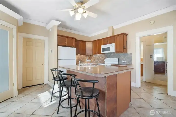 Oversized island in the kitchen with eating space. Close to the cozy pellet stove and large pantry.