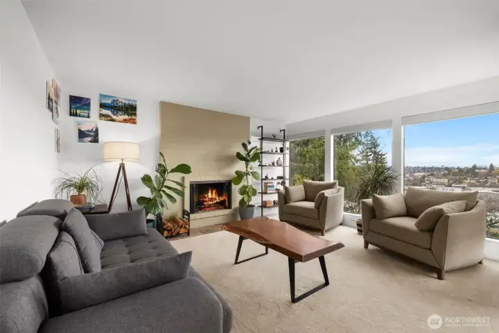 Inviting living room anchored by a cozy fireplace and framed by big windows with neighborhood views.