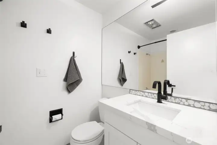 Bright and stylish full bath with modern vanity and playful design details.