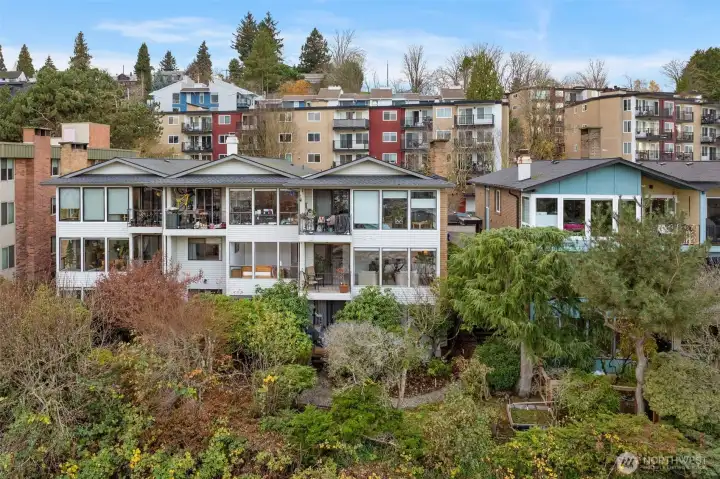 Elevated community living—modern architecture surrounded by lush greenery and hillside views.