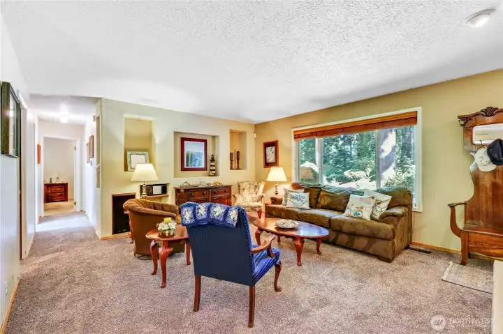 Another view of the living room looking down the hallway to the primary suite and full bath.