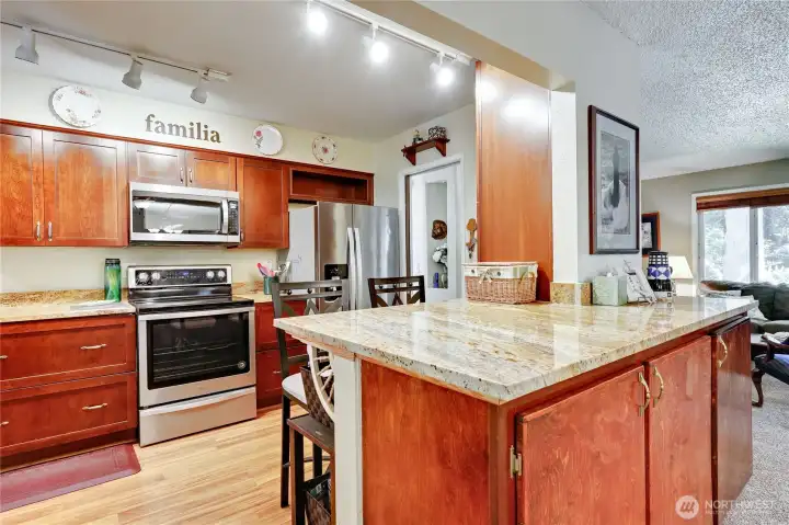 A view of the upgraded kitchen with granite countertops and stainless steel appliances.