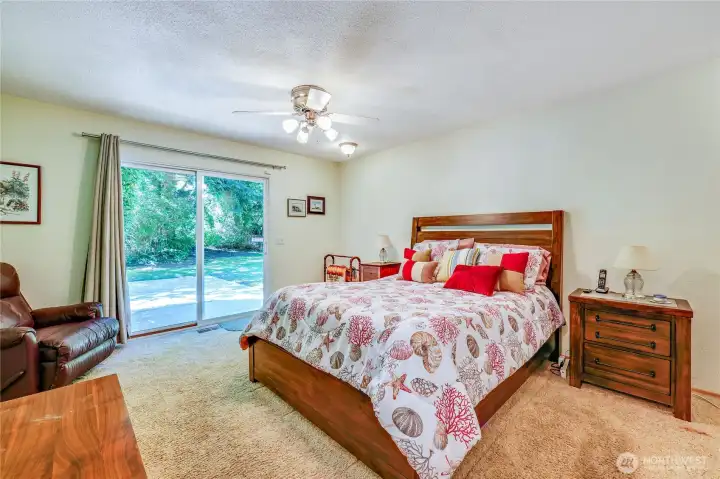 The primary bedroom with access to the back patio through the sliding glass doors.