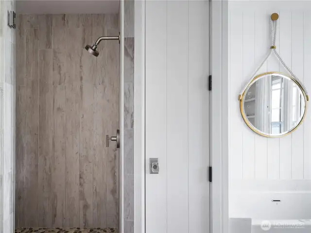 The primary bath shower with dual shower heads. Heated floors in this and every bathroom provide extra comfort.