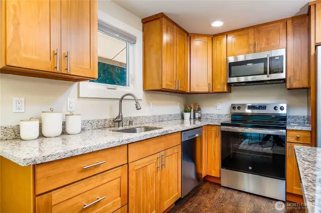 Modern finishes meet timeless function—granite counters, stainless steel appliances, and wood cabinets make cooking a joy.