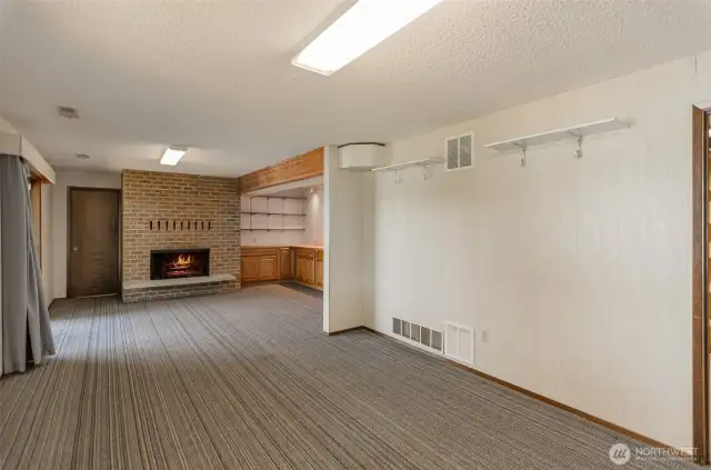 The daylight basement - the door to the left of the fireplace leads you to the additional partially finished room that was used by the sellers as their workshop area.
