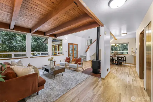The vaulted wood-beam ceiling sets a warm tone in this welcoming great room, where natural textures meet modern comfort. Open sightlines flow into the dining and kitchen areas, creating the perfect space for entertaining or relaxing fireside.