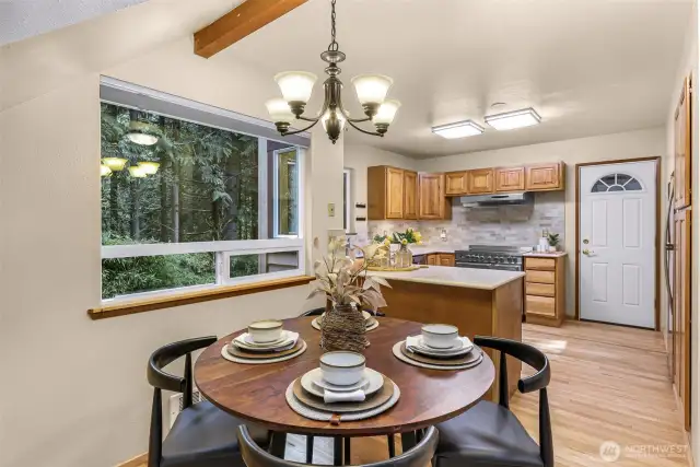 From this angle, the dining space glows with forest-filtered light while offering direct access to the kitchen. Ideal for casual meals or cozy conversation.