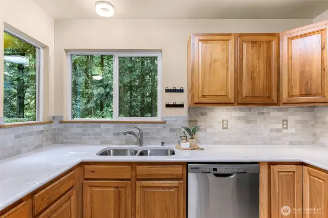 Nestled between corner windows, the deep stainless sink offers a serene view of the forest canopy. Every dish comes with a dose of peaceful nature.