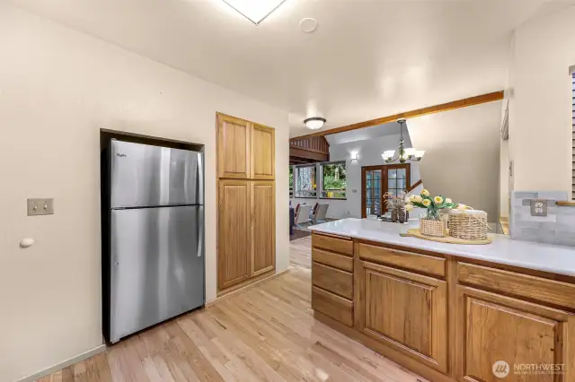 This view from the kitchen island highlights the seamless connection between prep space and the open living/dining area. Modern quartz counters and solid wood cabinetry blend durability with timeless appeal.