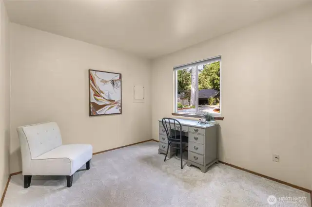 The third bedroom overlooks the front drive, making it ideal as a guest room, craft space, or office. Soft carpeting and a large window provide comfort and light.
