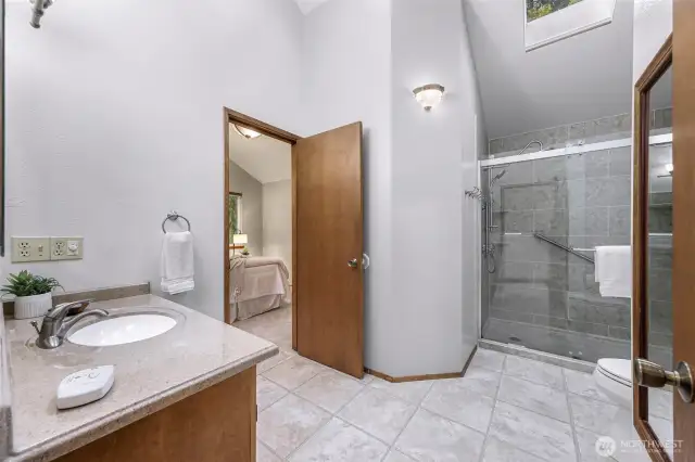 Featuring a tiled walk-in shower, skylight, and updated fixtures, this upper-level bathroom is both stylish and accessible. A thoughtful layout connects directly to the upper bedrooms.