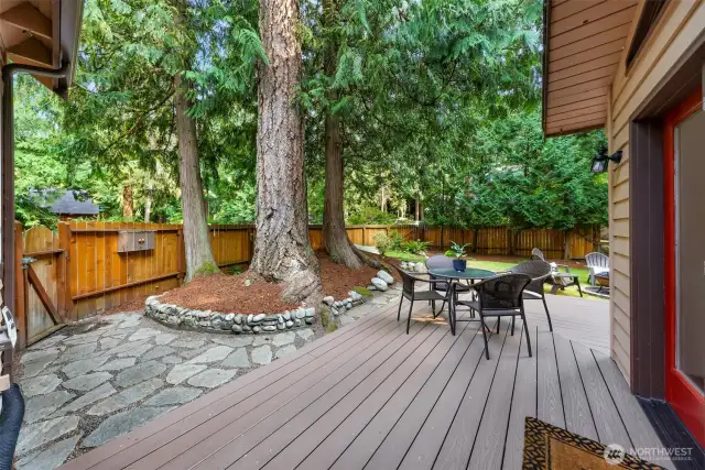Enjoy the natural ambiance and warmth around the firepit, surrounded by Adirondack chairs and lush greenery. A perfect spot for hosting or winding down.