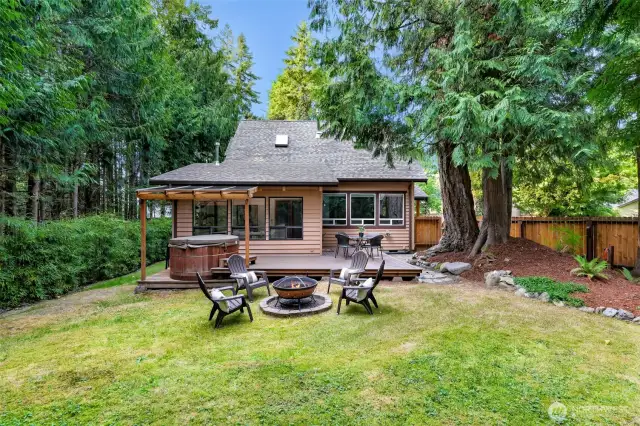 The rear view shows how the deck and hot tub connect seamlessly to the home’s main living areas. Relax under the covered patio or soak under the stars in this backyard retreat.