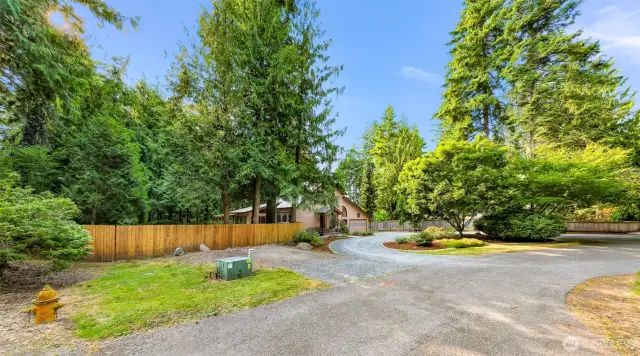 A long private drive curves gently into the property, revealing a peaceful setting tucked among the trees. The home’s cul-de-sac location offers seclusion and low traffic for added tranquility.