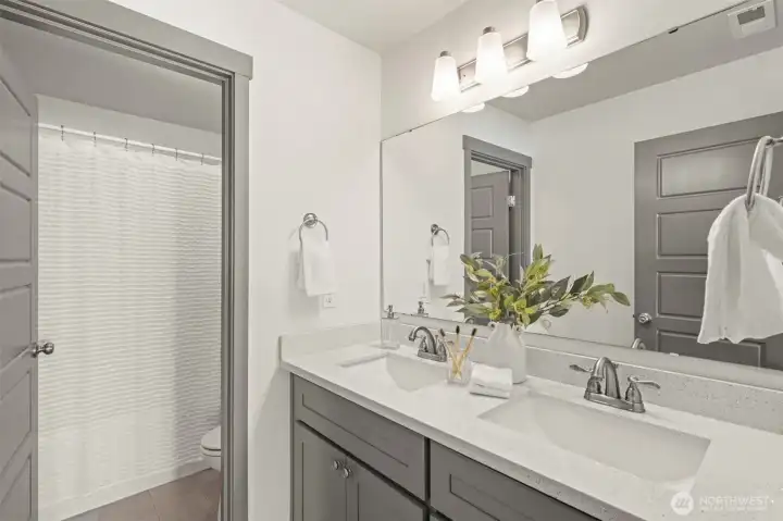 The upstairs hall bath also offers double vanities, private toliet and tub