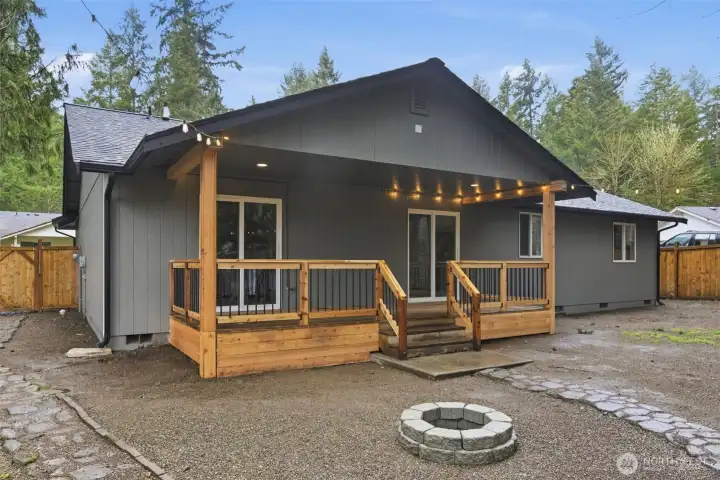 Covered back deck with access from both the primary bedroom and the dining room out to the firepit.