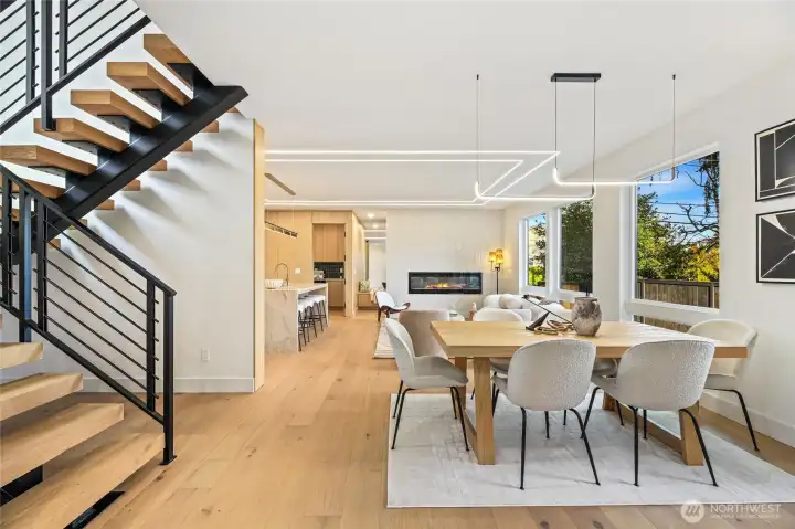 View from the dining area highlights the dramatic vertical volume and open staircase.
