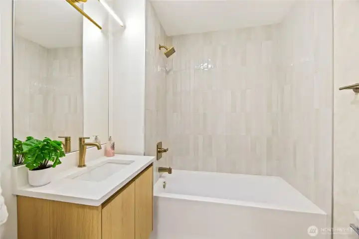 Designer secondary bathroom showcasing floor-to-ceiling tile and high-end finishes.