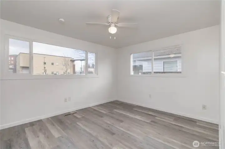 Primary bedroom with ceiling fan and big windows for that natural light