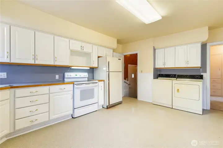 This is a large country kitchen with tons of storage. W&D were relocated up here in the past...You can see the back door off the driveway in this photo...down to the landing and right goes to the basement.