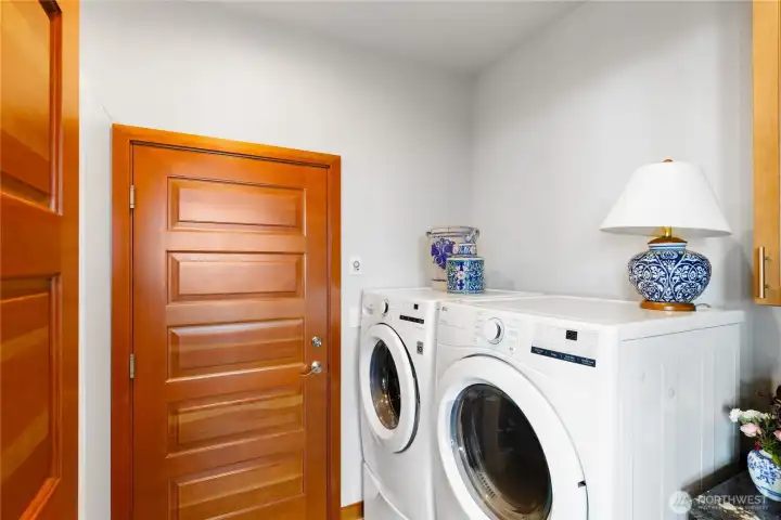 Oversized laundry has a sink and pantry shelf storage; located between the kitchen and garage.