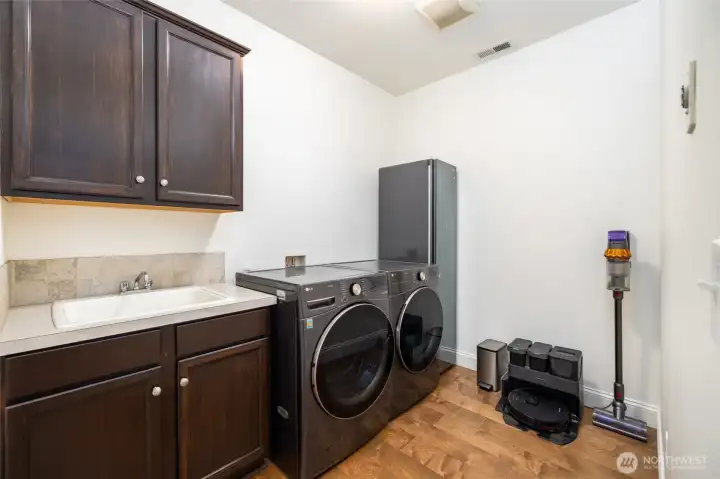 Dedicated laundry room on the main level, with storage and utility sink.